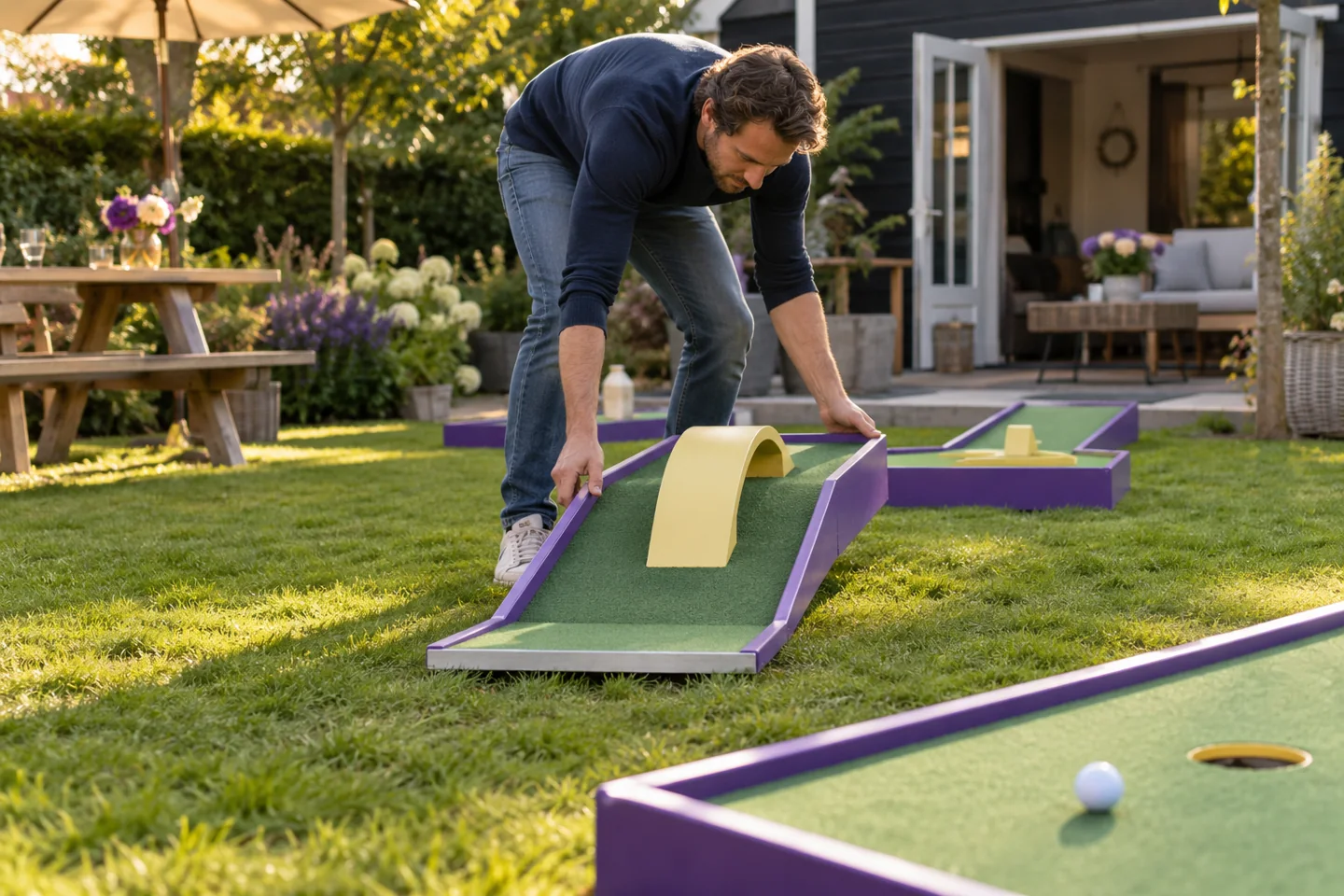 Een volwassene plaatst een draagbare minigolfmodule in een Nederlandse tuin.